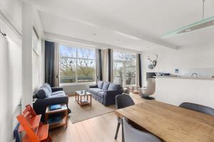 een woonkamer met blauwe stoelen en een tafel bij Hello Zeeland - Appartement Loverendale 38 in Domburg