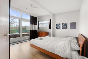 a bedroom with a large bed and a large window at Hello Zeeland - Appartement Loverendale 38 in Domburg