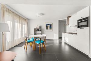 a kitchen with white cabinets and a table and chairs at Hello Zeeland - Appartement Domburgseweg 11-2 in Domburg