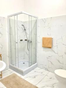 a shower in a bathroom with white marble walls at Vila de Santiago Apartment in Pedra Badejo