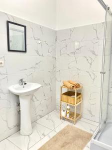 a white bathroom with a sink and a shower at Vila de Santiago Apartment in Pedra Badejo
