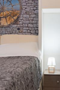 1 dormitorio con cama y pared de ladrillo en Panariello a Portamedina, en Nápoles