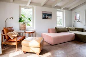 a living room with a couch and a chair at Het Grote Huis at Buitenplaats Zeeuwse Liefde in Westkapelle