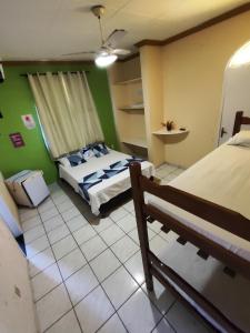a bedroom with a bed and green walls at pousada peracanga in Guarapari