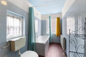 a bathroom with a tub and a toilet and a sink at Hello Zeeland - Vakantiehuis Weststraat 13A in Domburg +17 photos