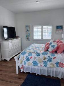 a bedroom with a bed with pillows and a tv at Carney's Reef NEW 1B 1B Pool Patio in Marathon