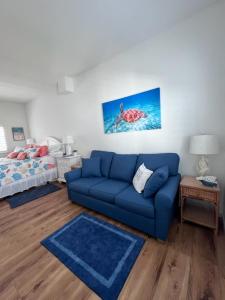 a living room with a blue couch and a bed at Carney's Reef NEW 1B 1B Pool Patio in Marathon +32 photos