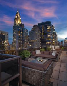 a rooftop patio with couches and a city skyline at night at Club Wyndham Midtown 45 in New York