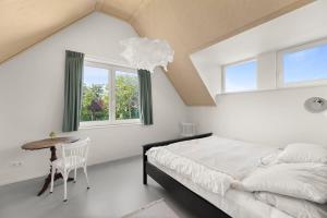 een slaapkamer met een bed, een tafel en een raam bij NEW Hello Zeeland - Vakantiehuis Jhr De Casembrootplein 19 in Domburg
