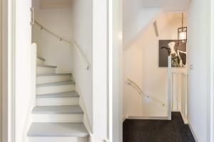 a staircase in a house with white walls and white stairs at De Grote Schuur at Buitenplaats Zeeuwse Liefde in Westkapelle