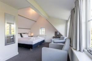 1 dormitorio con cama, sofá, cama y ventana en De Grote Schuur at Buitenplaats Zeeuwse Liefde, en Westkapelle
