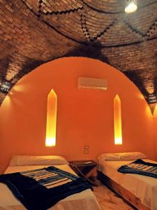2 camas en una habitación con pared de color naranja en فيلا شمس تونس, en Tunis