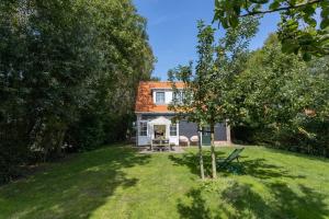 a small house with a yard with a tree at Het Kleine Huis at Buitenplaats Zeeuwse Liefde in Westkapelle +19 photos