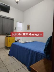 a room with a blue bed with a sign on it at Loft família moraes in Serra Negra