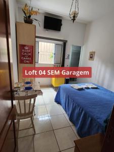 a room with a bed and a table and a tv at Loft família moraes in Serra Negra