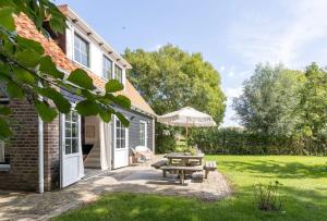 a house with a picnic table and an umbrella at Het Kleine Huis at Buitenplaats Zeeuwse Liefde in Westkapelle