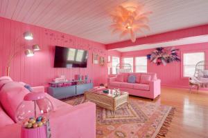 uma sala de estar cor-de-rosa com mobiliário cor-de-rosa e uma televisão em Inn the Pink One-in-a-Million Vacation Home em Myrtle Beach