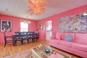 Sala de estar de color rosa con sofá rosa y mesa en Inn the Pink One-in-a-Million Vacation Home en Myrtle Beach