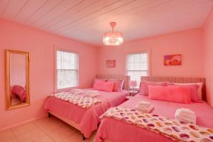 2 camas en una habitación con paredes rosas en Inn the Pink One-in-a-Million Vacation Home en Myrtle Beach