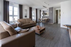 ein Wohnzimmer mit einem Sofa und einem Tisch in der Unterkunft Hello Zeeland - Duinhof V 1-7 in Cadzand