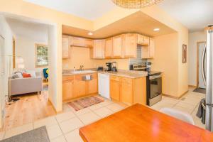 a large kitchen with wooden cabinets and a table at Relaxing Downtown 2BR Abode in Appleton
