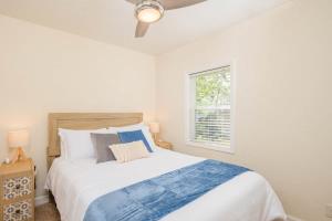 a white bedroom with a large bed and a window at Relaxing Downtown 2BR Abode in Appleton