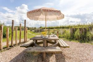a picnic table with an umbrella in a field at ÖÖD Sunset at Buitenplaats Zeeuwse Liefde in Westkapelle