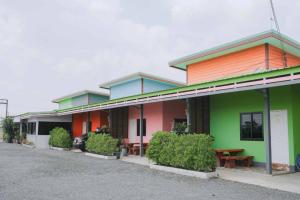 een felgekleurd gebouw met een tafel ervoor bij Manee House - บ้านมณี in Buriram