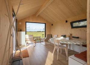 een kamer met een tafel en stoelen in een huis bij Hello Zeeland - Zeeuwse Liefde Tiny House 7 in Westkapelle