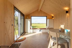 uma pequena casa com uma grande janela e uma mesa em Hello Zeeland - Zeeuwse Liefde Tiny House 8 em Westkapelle