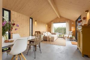 ヴェストカペレにあるHello Zeeland - Zeeuwse Liefde Tiny House 3のテーブルと椅子のあるキッチンとリビングルーム