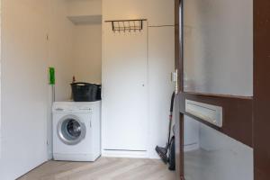 a laundry room with a washing machine and a washer at Hello Zeeland - Spaanse Galeien 35 in Retranchement
