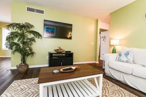 een woonkamer met een witte bank en een tv bij Island Breeze Pet Friendly Bungalow w Pool in Myrtle Beach