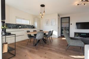 a kitchen and dining room with a table and chairs at Hello Zeeland - vakantiewoning Knuitershoek 80 in Kloosterzande