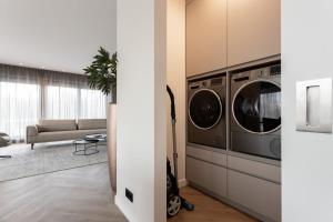 a living room with two washers and a couch at Hello Zeeland - Huisje aan de Duinen in Zoutelande