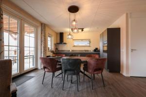 a kitchen and dining room with a table and chairs at Hello Zeeland - vakantiewoning Knuitershoek 66 