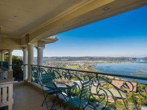 Un balcón con sillas y vistas al océano. en Villa Paradisa Guest House, en Knysna