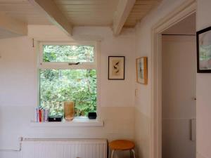 ein Fenster in einem Zimmer mit einem Tisch und einem Stuhl in der Unterkunft Hello Zeeland - Vakantiewoning 't Schrijvershuisje in Hengstdijk