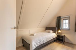 Dormitorio pequeño con cama en el ático en Hello Zeeland - vakantiewoning Knuitershoek 102 