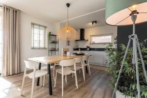 a kitchen and dining room with a table and chairs at Hello Zeeland - vakantiewoning Knuitershoek 72 in Kloosterzande