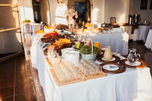 a buffet of food on a white table at Hotel Fernandão in Pouso Alegre