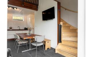 a kitchen and dining room with a table and chairs at Hello Zeeland - Vakantiewoning Kalfhoeksepad 8 in Aagtekerke