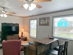 a living room with a tv and a couch and a table at Beach Hut - Half Duplex Just a Few Blocks to Sand Shore and Jetty Park in Freeport