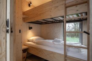 Etagenbett in einem Zimmer mit Fenster in der Unterkunft Hello Zeeland - Tiny House Zeeuwse Liefde 6 in Westkapelle