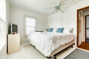 a white bedroom with a bed and a ceiling fan at Beechwood Bungalow - Where Comfortable Coastal and Calm Meet Waves Water and WOW in Freeport