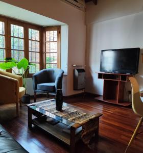 een woonkamer met een tv en een salontafel bij Tanino Home Suites in Mendoza