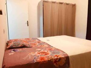 洛美的住宿－TANIA GUESTHOUSE，一间卧室配有一张带花卉毯子的床