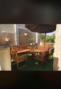 eine Terrasse mit einem Tisch, Stühlen und einem Sonnenschirm in der Unterkunft TANIA GUESTHOUSE in Lomé