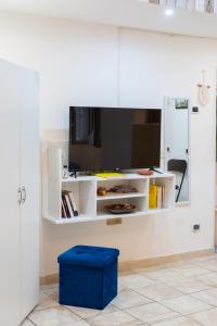 a white cabinet with a blue stool in a room at Panariello a Portamedina in Naples