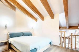 1 dormitorio con paredes blancas y vigas de madera en One bedroom apartement with enclosed garden and wifi at Mourisca, 